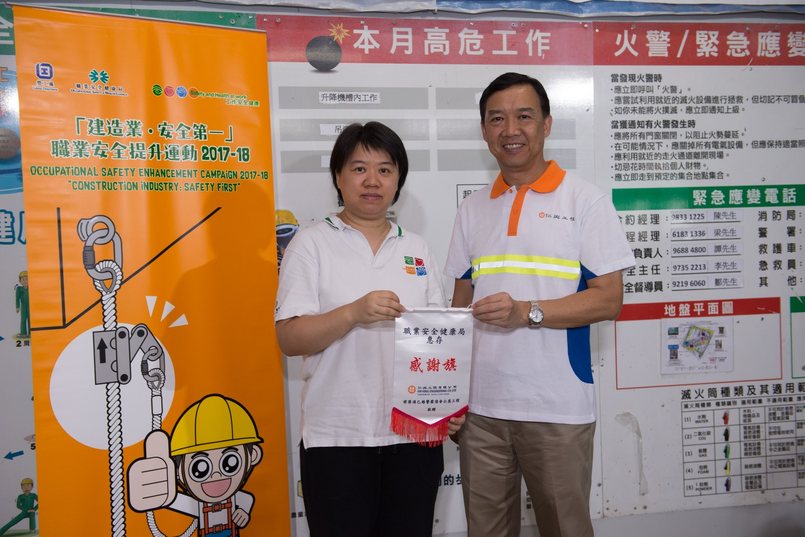 Mr TC Chu, Managing Director of Hip Hing Construction, presents commemorative pennant to the representative of Occupational Safety and Health Council