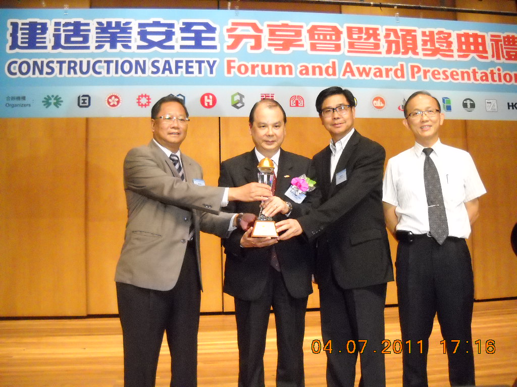 Mr Matthew Cheung, JP, Secretary for Labour and Welfare (Left 2) presents the Best Fall Arresting Safety Enhancement Program for working at Height Gold Award  to Senior Project Manager Mr. Wong Cheuk Kwong (Left 1)